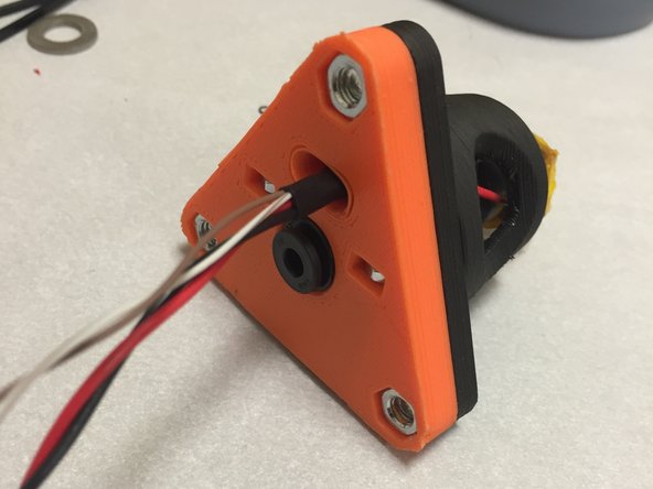 Add a small piece of heat shrink tubing on the wires, and slide it down to the slotted wire routing hole.