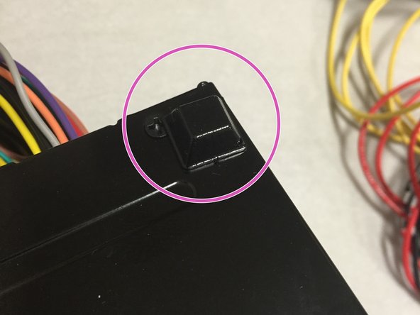 Add rubber feet to the four corners of the power supply as shown.