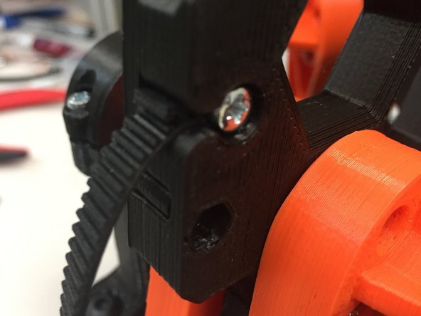 Insert an M3 x 12L pan-head screw through the belt, and use a screwdriver to thread it into the pulley so that it sits flush.