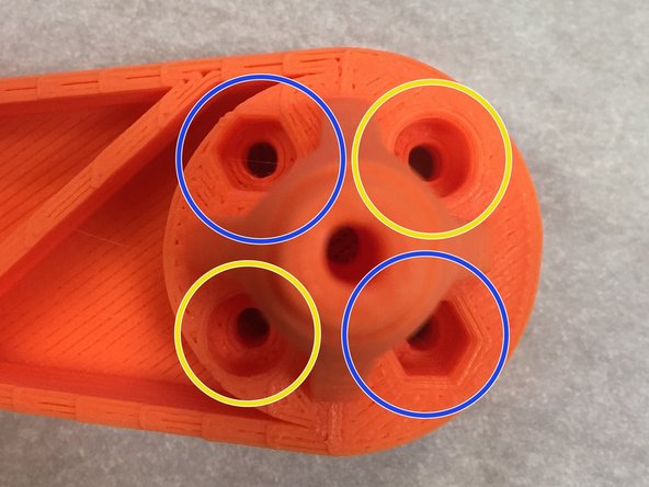 Insert two M3 x 30mm? pan-head machine screws into each orange arm.  NOTE: Only insert the screws into the ROUND counter-bored holes.