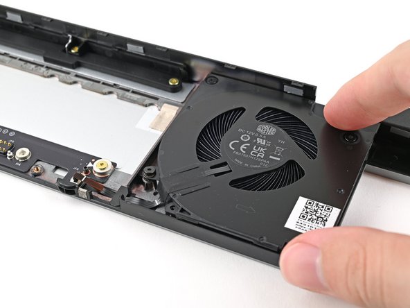 Place the right fan onto the Expansion Bay Shell, making sure to thread the cable through its slot.