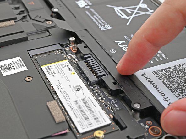 Lightly press the battery down to connect it.