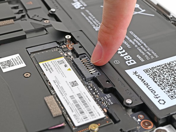 Lightly press the battery down to connect it.