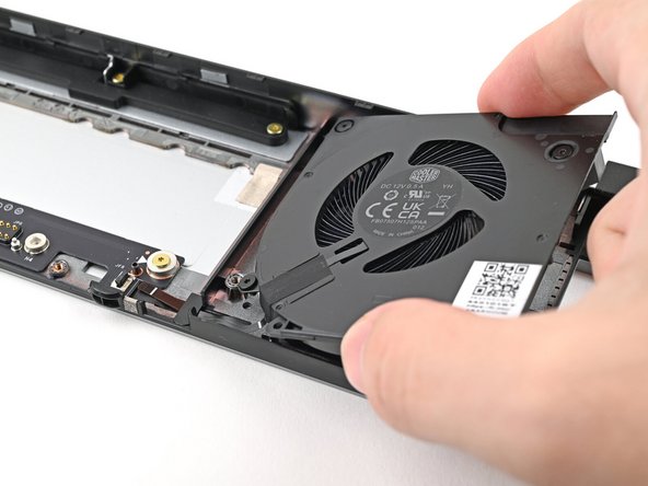 Place the right fan onto the Expansion Bay Shell, making sure to thread the cable through its slot.