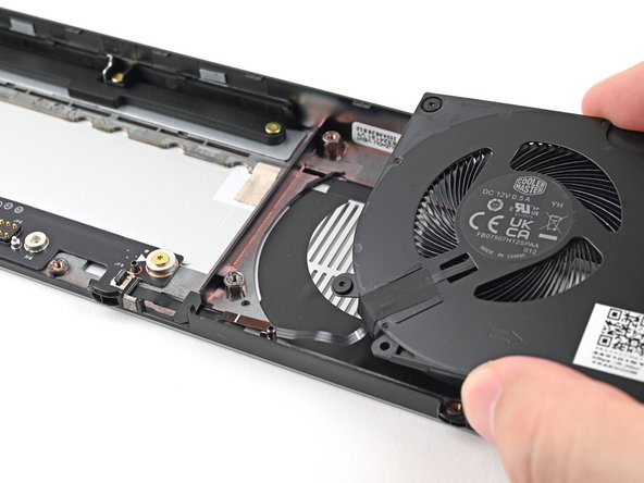 Place the right fan onto the Expansion Bay Shell, making sure to thread the cable through its slot.
