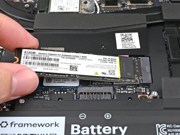 Insert the SSD into the socket at a shallow angle. The gold contacts should mostly be covered by the socket.