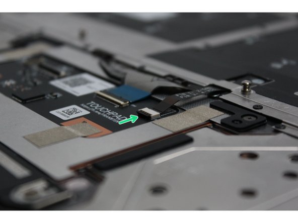 Using the spudger end of the Framework Screwdriver or your fingernail, disconnect the Keyboard Backlight cable from the Touchpad Module by switching the black latch up and sliding the cable straight out.