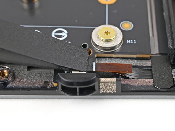 Use the flat end of your Framework Screwdriver, or a clean fingernail, to press down the locking tab on the right fan ZIF connector.
