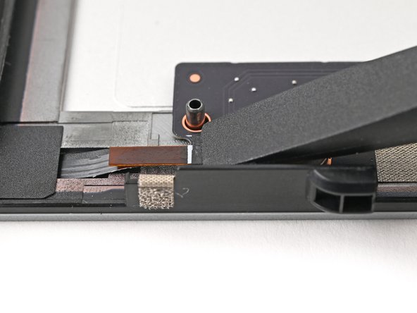 Use the flat end of your Framework Screwdriver, or a clean fingernail, to press down the locking tab on the left fan ZIF connector.