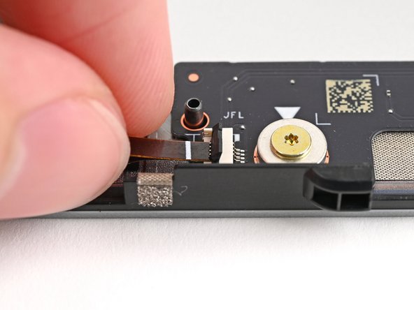 Use the flat end of your Framework Screwdriver, or a clean fingernail, to press down the locking tab on the left fan ZIF connector.