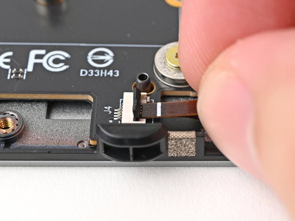 Use the flat end of your Framework Screwdriver, or a clean fingernail, to press down the locking tab on the right fan ZIF connector.