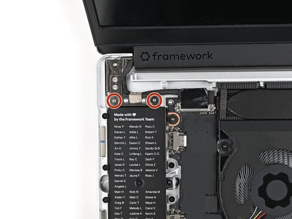 While supporting the Top Cover with one hand, use your Framework Screwdriver to install two 4.0 mm‑long T5 Torx screws on each Hinge connected to the Bottom Cover (four total).