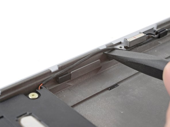 Starting at one speaker, use the flat end of a spudger, or your fingers, to lift the speaker cable out of its rubber clips.