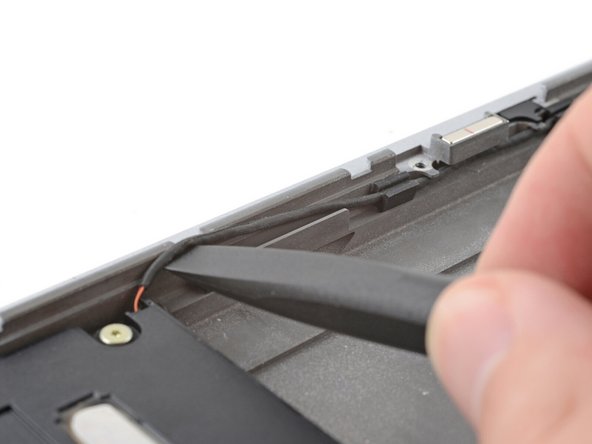 Starting at one speaker, use the flat end of a spudger, or your fingers, to lift the speaker cable out of its rubber clips.