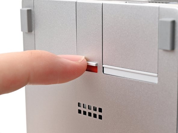 If there's a red bar showing under the Expansion Card latch, use your finger to flip the latch and lock the Expansion Card into its slot.