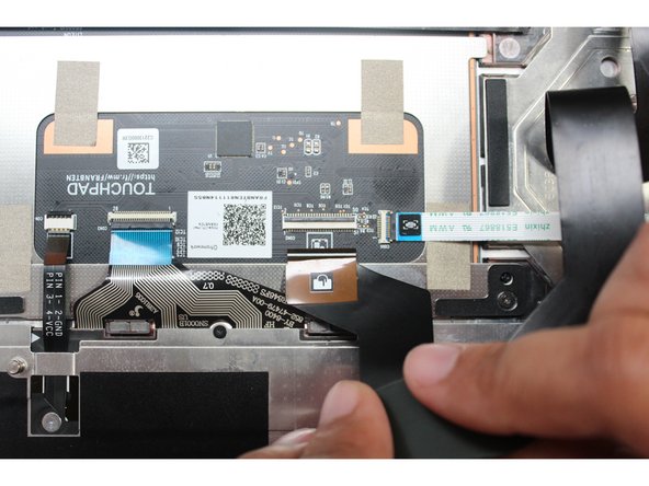 Connect the Touchpad Cable. Make sure the black latch is flipped up so that you can slide the cable into the connector.