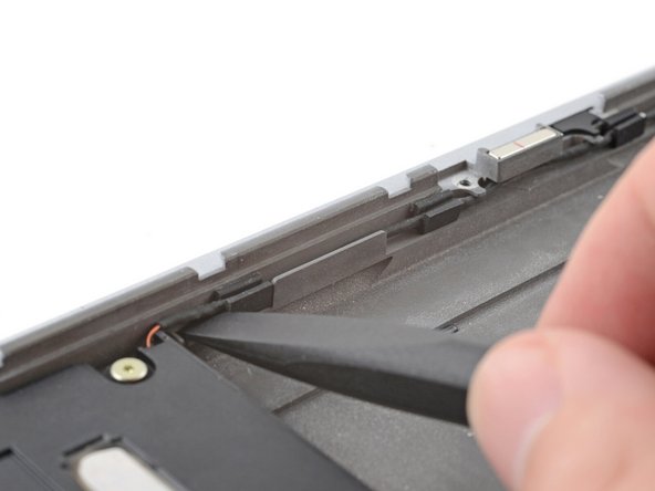The speaker cable is routed along the bottom edge of the laptop. The next three steps will demonstrate how to unclip it.