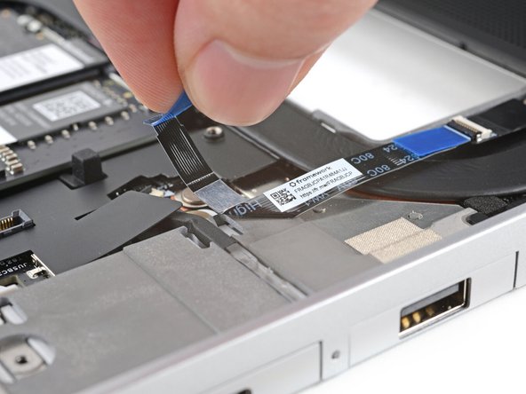 The fingerprint sensor cable is lightly adhered to the laptop's frame.
