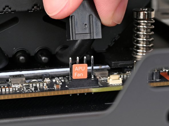 Slide the main fan cable over the four-pronged connector labeled &quot;APU Fan,&quot; making sure the orange label slots between the vertical lines.