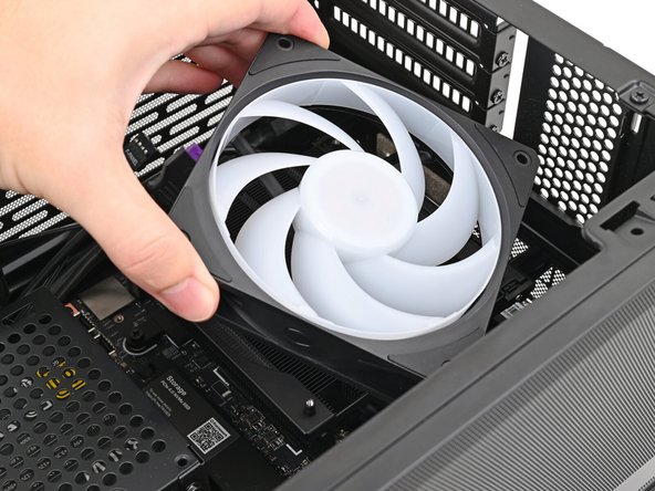 Orient the fan so its label is facing downward and the cable(s) are pointing towards their sockets on the Mainboard.