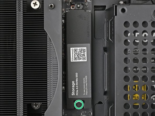 Insert your Framework Desktop Screwdriver into the captive screw on the primary storage heat spreader and press it flat to the Mainboard.