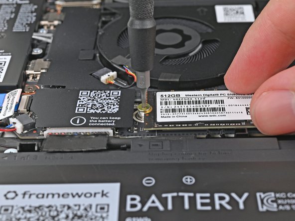 While holding the SSD flat to the Mainboard, use your Framework Screwdriver to install the 3.0 mm‑long T5 Torx screw securing the SSD.