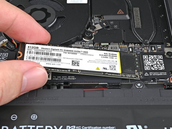 Insert the SSD into the socket at a shallow angle. The gold contacts should mostly be covered by the socket.