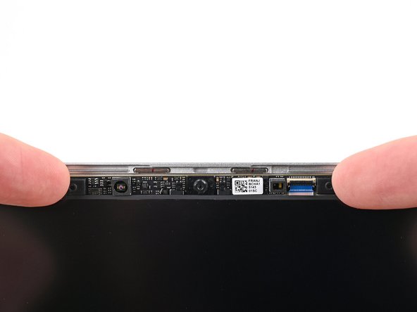 Place the webcam into its spot above the display, making sure the cable slides into its socket.