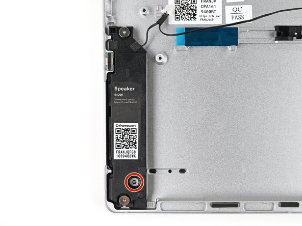 Place the left Speaker into its slot on the Bottom Cover, making sure it's aligned with its screw posts and threaded through its alignment peg.