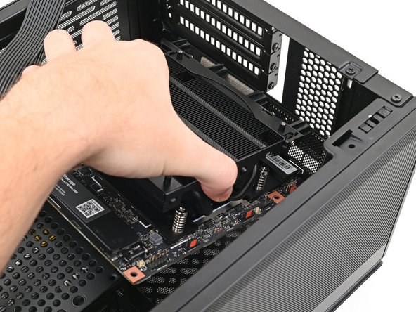 Grip the Mainboard by the heatsink and place it into its cutout, making sure the ports aligns with its slot in the case.