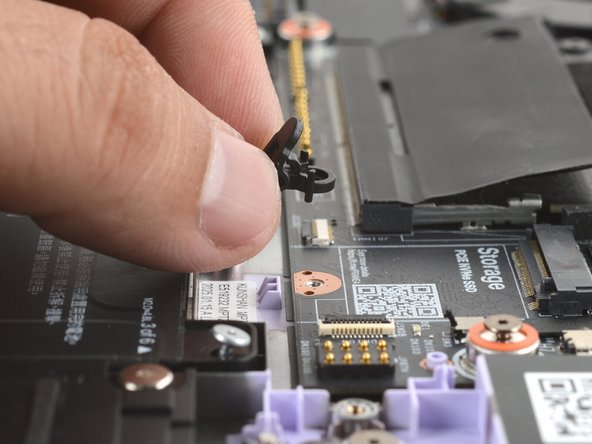 Use your fingers to lift and remove the SSD clip.