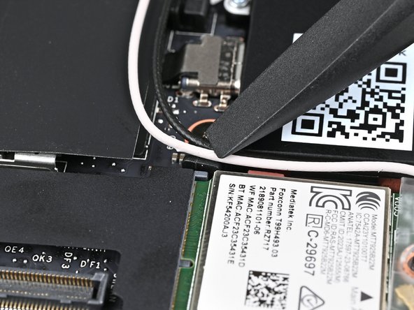Use the flat end of your Framework Screwdriver to press the two Antenna Cables into their rubber clips on the Mainboard.