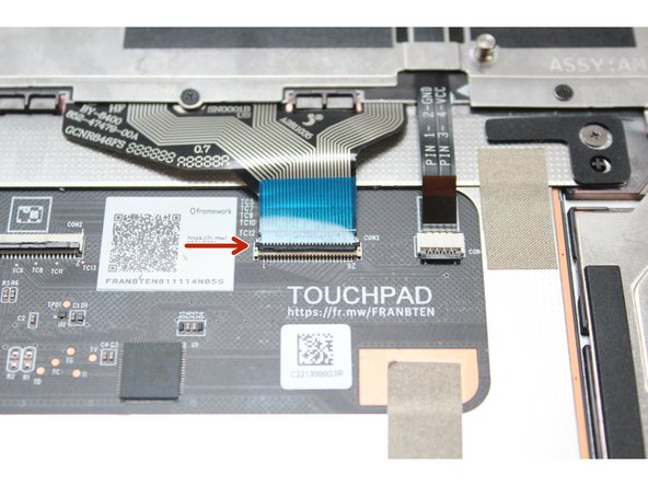 Using the spudger end of the Framework Screwdriver or your fingernail, disconnect the Keyboard Membrane from the Touchpad Module by switching the black latch up and sliding the cable straight out.