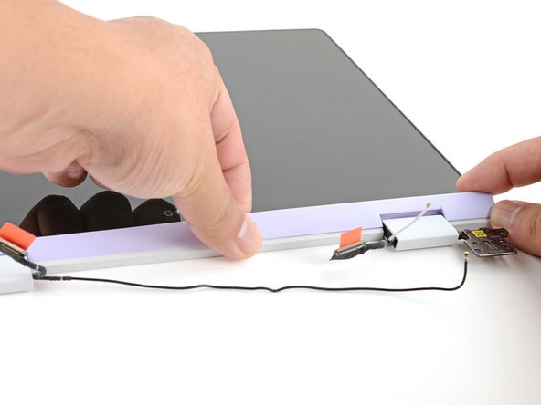 Slide your fingers under the top edge of the Display Cover to release it from the laptop.