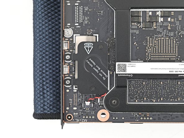 Use your Framework Desktop Screwdriver to install the two captive T5 Torx screws securing the RTC battery cover.