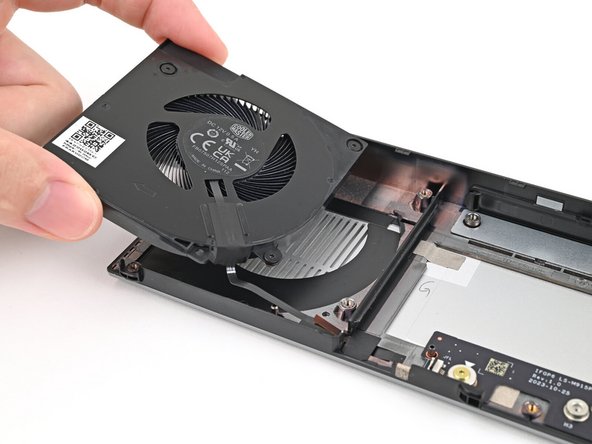 Place the left fan onto the Expansion Bay Shell, making sure to thread the cable through its slot.