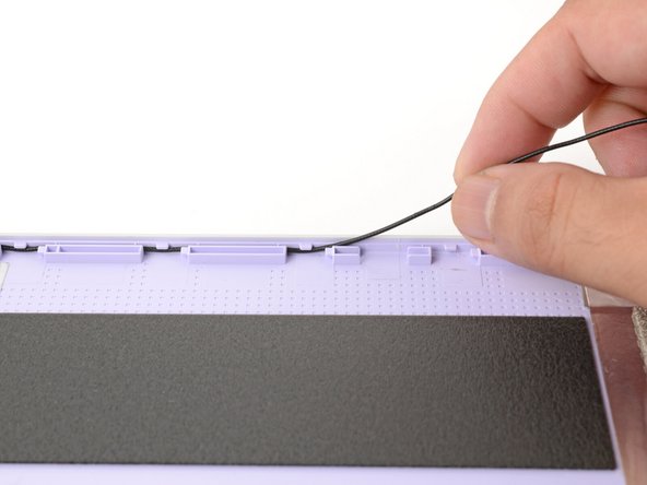 Carefully guide the black antenna cable out of its channel.