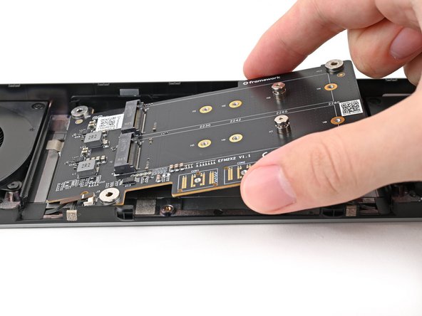 Flip over the adapter and place it into its spot in the Expansion Bay Shell, making sure it slots into its alignment pegs.