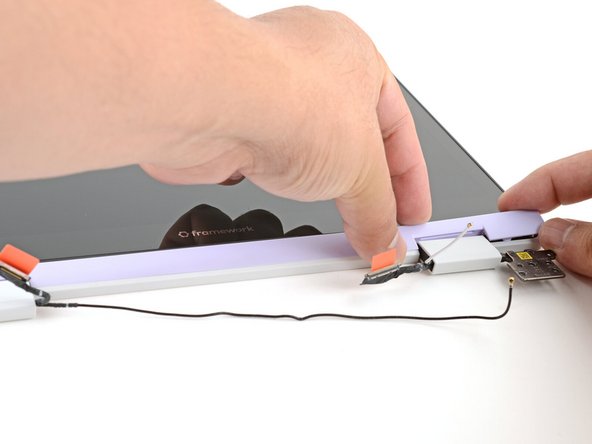 Slide your fingers under the top edge of the Display Cover to release it from the laptop.