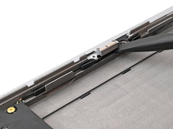 Use the flat end of your Framework Screwdriver to push the speaker cable back into its clips along the bottom edge of the laptop.