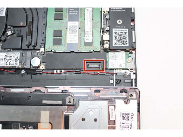 Using slight force, connect the Touchpad Cable by aligning it to the socket on Mainboard. You should hear it click into place once properly connected.