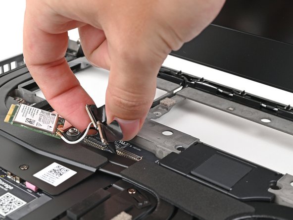 Lift the display, webcam, and Wi-Fi module cables out of their slot in the frame enough to give room for the Mainboard to lift straight up.