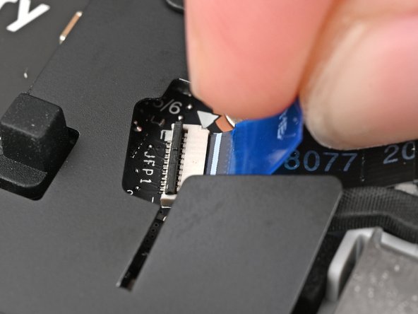 Use tweezers, or your fingers, to grip the blue pull tab and slide the fingerprint sensor cable straight into its socket.