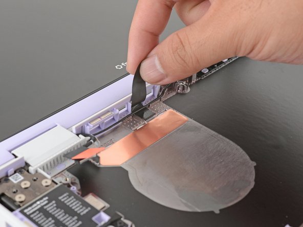 Use your fingers to lift the black plastic loop securing the antenna cable, near the heat vents by the left hinge.