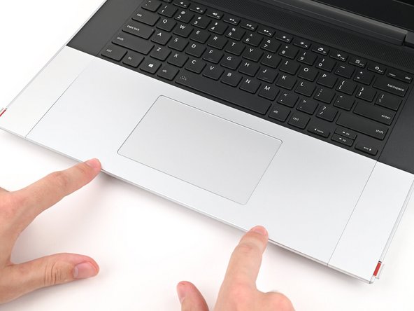 Press the Touchpad Module down and slide it into place so it lines up evenly with the bottom edge of the laptop.