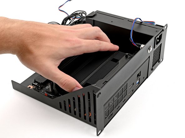 Align the I/O ports with its cutout in the Tray and the screw posts with the screw holes on the Mainboard.