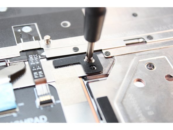 Then unscrew the two fasteners holding the Touchpad Module, indicated in orange.