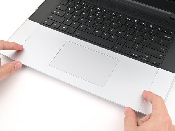 Press the Touchpad Module down and slide it into place so it lines up evenly with the bottom edge of the laptop.