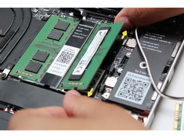 Using both fingers, gently pull the top and bottom metal release clips away from the Memory just enough for the module to pop up.