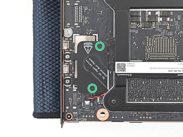 Use your Framework Desktop Screwdriver to loosen the two captive T5 Torx screws securing the RTC battery cover.